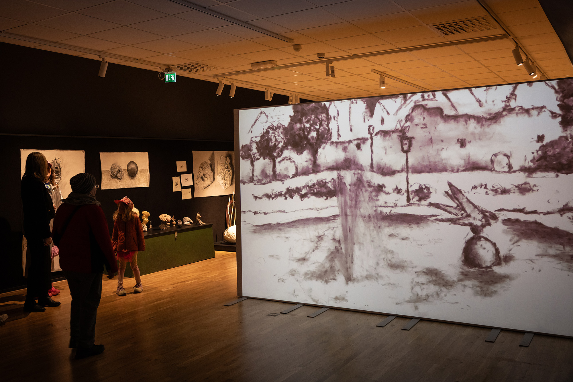 En duk med tecknad film. Utställning på museum. Människor rör sig i förgrunden.