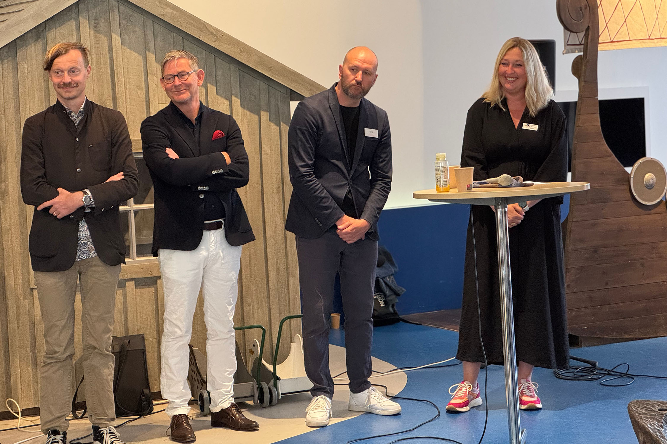 En kvinna och tre män i en paneldebatt.