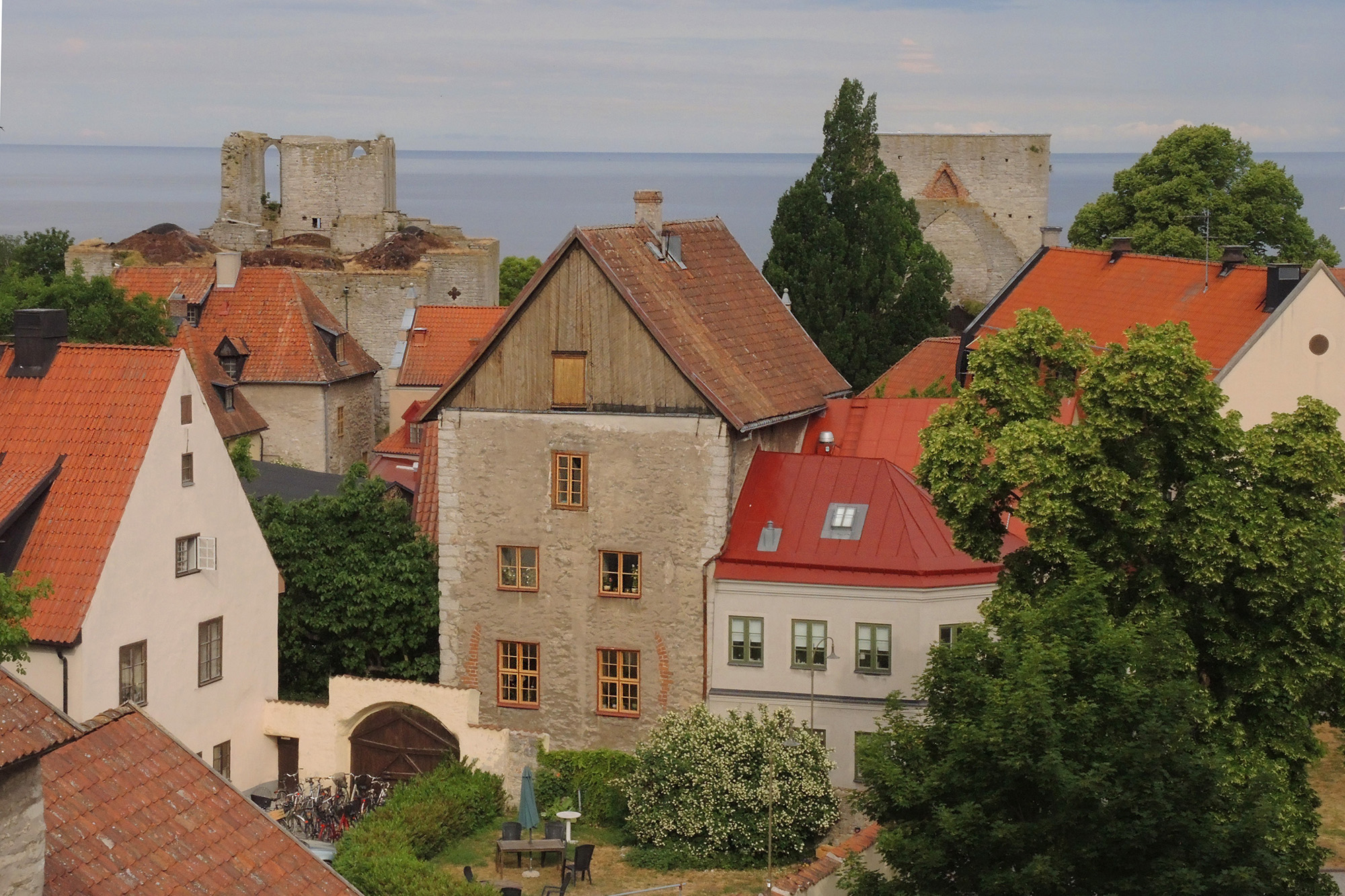 En medeltida stad. Kalkstenshus. Tegeltak. Havet i bakgrunden. Visby.