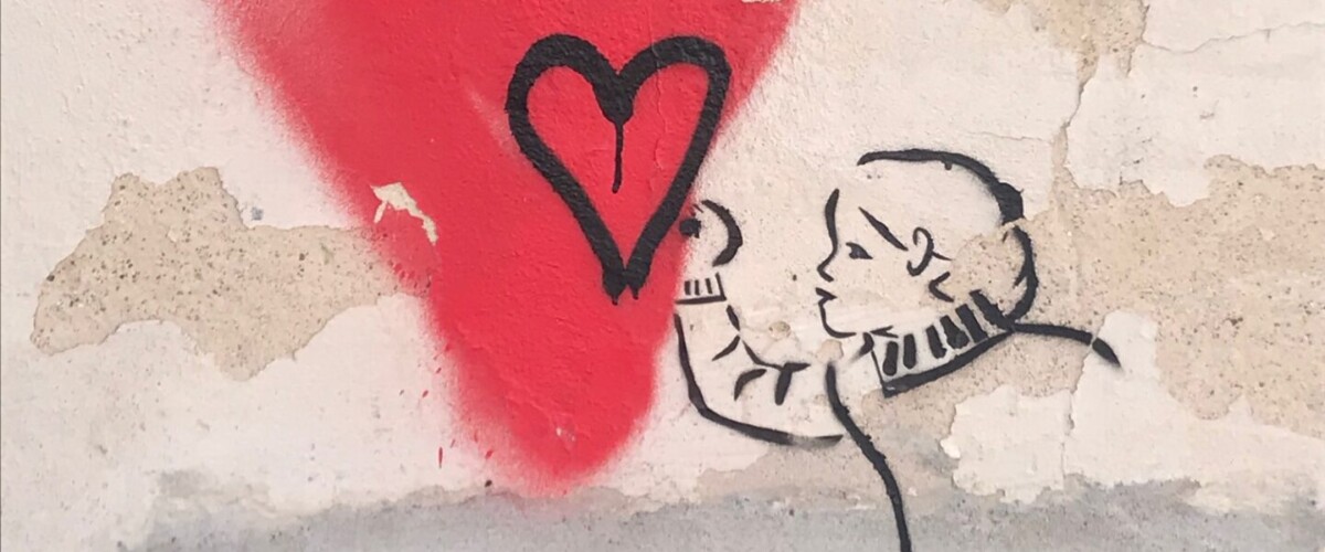 Målning på vägg föreställande ett hjärta och en person